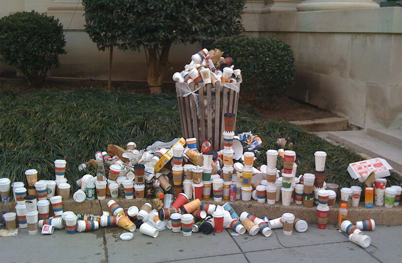 disposable cups by garbage can